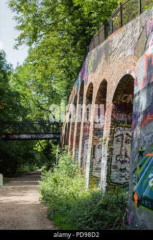 Graffitis colorés pulvérisés sur les ponts de chemin de fer désaffectée le long de la prairie-parc à pied, une ancienne ligne de chemin de fer et maintenant Londres réserve naturelle locale la plus longue Banque D'Images