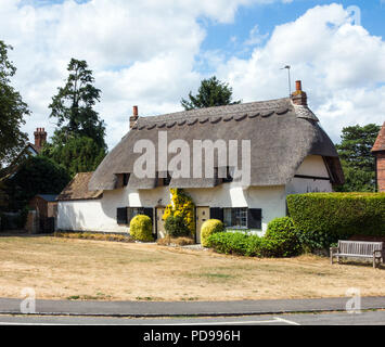 Chalet de campagne anglais traditionnel avec toit en chaume sur le village vert dans le village de Cuddington Buckinghamshire Angleterre Royaume-Uni Banque D'Images