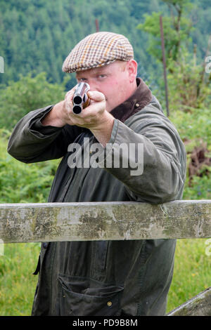 Agriculteur en pointant un fusil à canon double de l'avant Banque D'Images