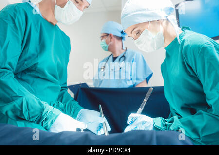 Médecin chirurgicale en pleine concentration sur l'opération Banque D'Images