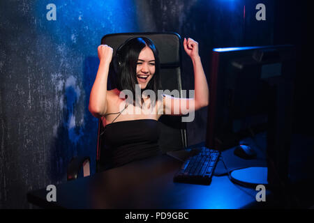 Portrait d'une jeune fille heureuse qui se réjouit après avoir remporté un jeu vidéo, - une célébration qui gagne dans l'émotion de jeu concept. Banque D'Images