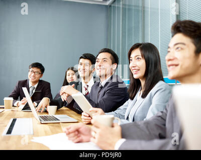 Groupe d'happy smiling asian corporate business personnes écoutant présentation en salle de réunion du bureau Banque D'Images