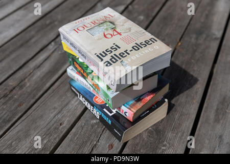 Pile de livres - Jussi Adler-Olsen, Camilla Läckberg, etc. (en danois) - sur terrasse en bois Banque D'Images
