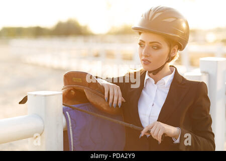 Cavalier élégant femme en casque avec fouet Banque D'Images