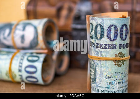 Roulé et empilés 20000 billets forint avec une boîte en bois vintage fermée à l'arrière-plan close up Banque D'Images