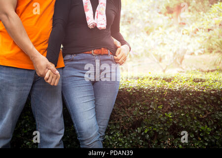 Middle aged woman standing in garden avec flare lumière en arrière-plan. Banque D'Images