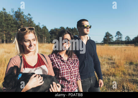 Petit groupe de jeunes bénéficiant d'extérieur avec de magnifiques bouledogue français. Journée ensoleillée. Nature de la montagne. Banque D'Images