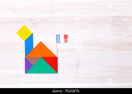 Au-dessus de figures en forme de tangram house sur table en bois avec drapeau Français Banque D'Images
