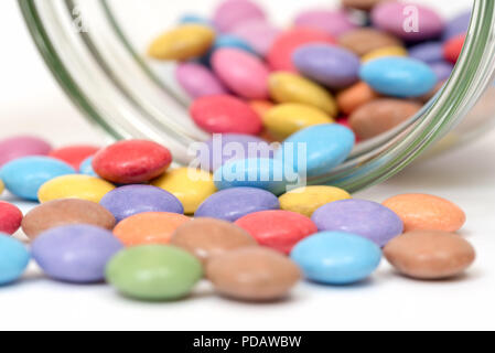 Close up de bonbons enrobés de sucre coloré de spillng un pot Banque D'Images