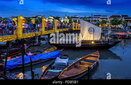 Hoi An Ancient City bridge at night avec de nombreux bateaux et des lumières. Vue panoramique du pont et des magasins sur le canal. Banque D'Images