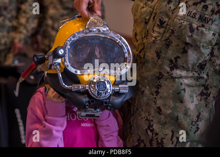 180802-N-SH284-0179 SEATTLE (02 août 2018) un enfant essaie sur un casque de plongée à un affichage statique présentée par la Station Navale Everett casier de plongée à l'Aquarium de Seattle lors de la 69 e semaine de la flotte Seafair annuel. Seafair Fleet Week est une célébration annuelle de la mer où les services marins, marines et de la Garde côtière des États-Unis en visite de membres de la Marine et des navires de la Garde côtière et des navires du Canada font de la ville un port d'escale. (U.S. Photo par marine Spécialiste de la communication de masse 2e classe Vaughan/Aneth) Parution Banque D'Images