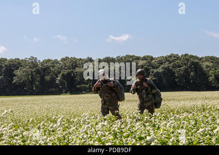 Les parachutistes de l'Afrique du Sud à pied à travers Château Zone de chute après avoir participé à un saut dans le cadre de la familiarisation à l'Université de Leapfest Rhode Island, West Kingston, R.I., 3 août 2018. Est le plus grand, le Leapfest plus ancien international, de formation en parachutisme en ligne statique de la concurrence et de l'événement organisé par le 56e commandement de troupes, la Garde nationale de Rhode Island pour promouvoir des techniques de niveau et l'esprit de corps au sein de la communauté dans l'internationale. (U.S. Photo de l'armée par le Sgt. Josephine Carlson) Banque D'Images