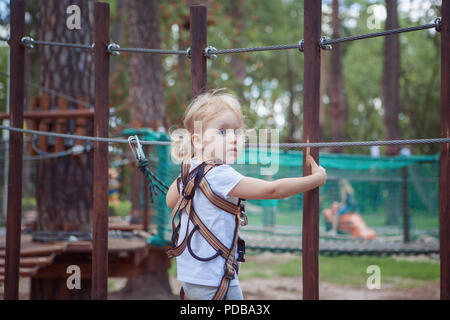 Portrait d'une petite fille en parc. Elle surmonte l'obstacle. Banque D'Images