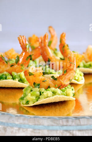 Collation de chips de remplissage avec de l'avocat et crevettes sautées aux herbes aromatisées. Banque D'Images