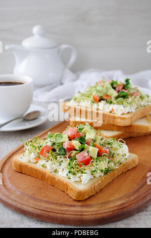 Pour le petit-déjeuner Sandwich tendre, juteuse de germes de luzerne germées avec ricotta, tomate et de tranches d'avocat, avec une tasse de café ou de thé, qui Banque D'Images