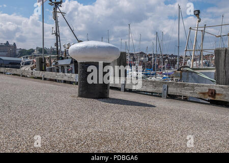 Bollard en noir et blanc sur le quai à côté du port de Scarborough. Banque D'Images