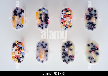 Vue de dessus les popsicles maison délicieux avec les fruits et baies sur gris Banque D'Images