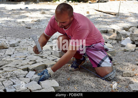 Tailleur de granit réglage jeux de pavage en position dans ce qui va devenir un sentier public, Prague, République Tchèque Banque D'Images