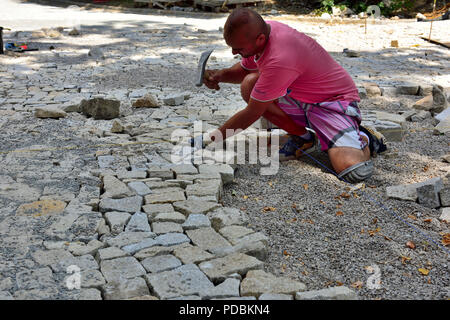 Tailleur de granit réglage jeux de pavage en position dans ce qui va devenir un sentier public, Prague, République Tchèque Banque D'Images