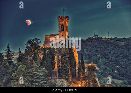 Eclipse de Lune rouge sur la tour de l'horloge en Italie Banque D'Images