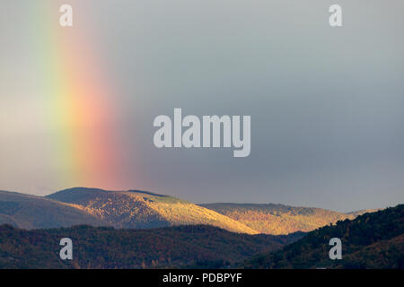 Belle et surréaliste vue d'une partie d'un arc-en-ciel sur certaines collines Banque D'Images