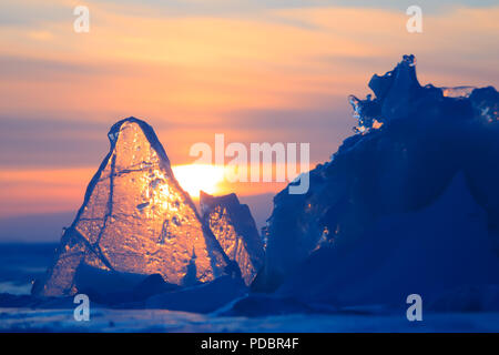 Violet transparent glace hummockée Baikal brille à travers la fente coucher du soleil Banque D'Images