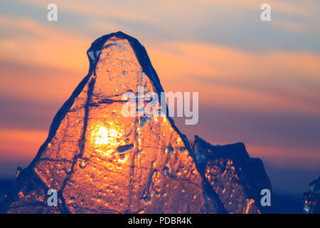 Violet transparent glace hummockée Baikal brille à travers la fente coucher du soleil Banque D'Images