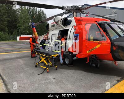 Une Garde côtière Air Station Kodiak MH-60 Jayhawk équipage d'medevaced a 51 ans homme à partir de la dévotion des navires de pêche 34 milles au sud-ouest de Cordova, en Alaska, le 4 août 2018. L'homme aurait subi une blessure à la tête puis ensuite tombé et avait besoin d'une évacuation sanitaire pour recevoir des soins médicaux de niveau supérieur. Photo de la Garde côtière des États-Unis. Banque D'Images