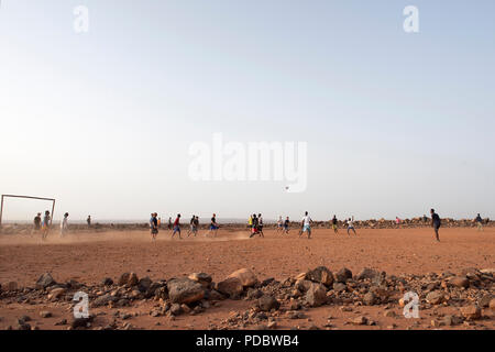 Service des membres affectés à la Force opérationnelle interarmées - Corne de l'Afrique participent à un match amical de football avec les enfants du village voisin, à l'extérieur du village de Chebelley, Djibouti, 3 août 2018. Plus de 30 soldats et aviateurs canadiens se sont portés volontaires pour l'activité de sensibilisation organisée par le 404e Bataillon des affaires civiles. (U.S. Air National Guard photo par le Sgt. Sarah Mattison) Banque D'Images