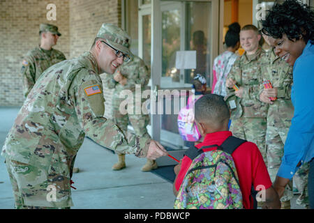 Des soldats Spartan 6e Escadron, 8e régiment de cavalerie blindée, 2e Brigade Combat Team, 3e Division d'infanterie, bienvenue les enfants entrant sur leur première journée d'école de Hinesville, ga., août 6. (U.S Army photo par le Sgt. Leo Jenkins / relâché) Banque D'Images