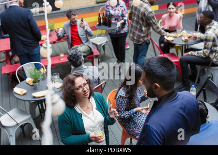 Les amis socializing at party on patio Banque D'Images