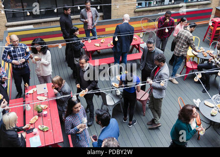 Les amis socializing at party on patio Banque D'Images