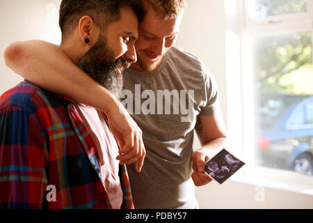 Homme affectueux couple gay à la photo d'échographie à Banque D'Images