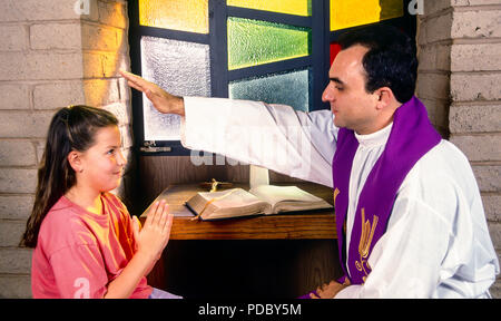 Prêtre catholique bénédiction enfant avec plus de main tête de l'enfant au cours de la réconciliation. © Myrleen ....Pearson Ferguson Cate Banque D'Images