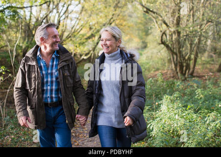 Heureux, affectueux young couple holding hands and walking in autumn park Banque D'Images