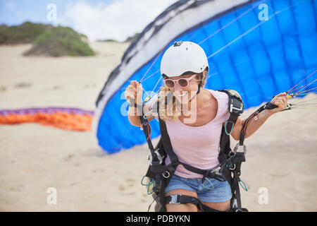 Female parapentiste avec parachute on beach Banque D'Images