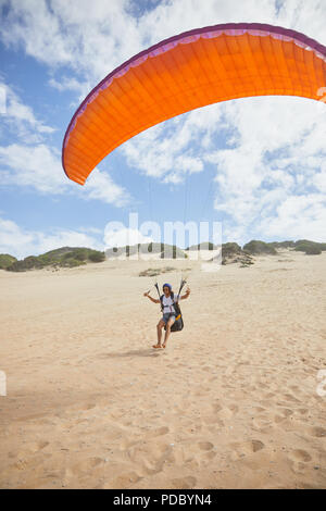 Parapente mâle tournant avec le parachute beach Banque D'Images