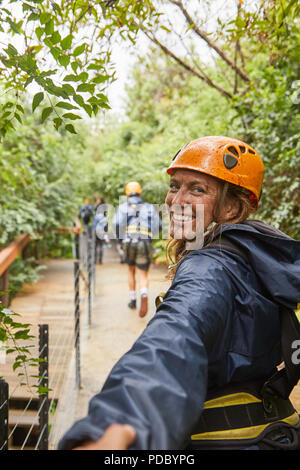 Portrait heureux, muddy woman enjoying tyrolienne Banque D'Images