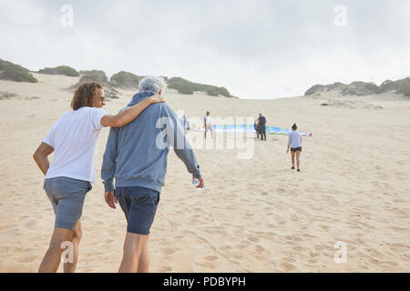 Amis de parapente walking on beach Banque D'Images