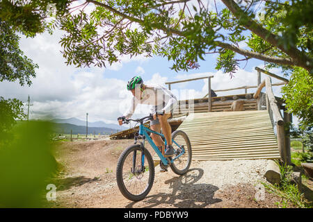 L'accent man mountain biking bas sunny parcours ramp Banque D'Images