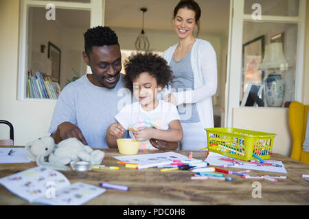 Les parents et la fille à la table de coloriage Banque D'Images