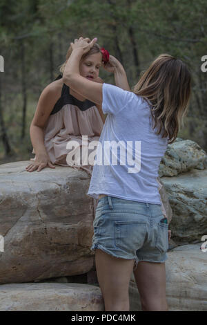 Jeune femme portant la robe d'une tante, en tant que tante organise la robe pour une photo prise à l'extérieur, sur les rochers. À la fois attrayante, verticale et les deux releas Banque D'Images