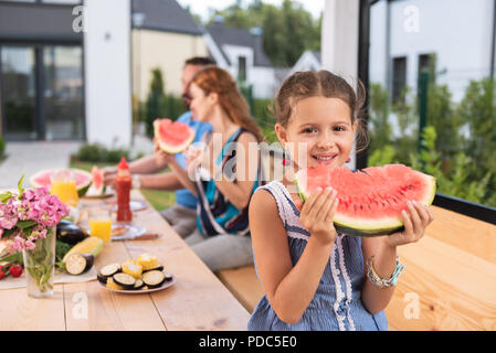 Girl enjoying petit mignon sa nourriture Banque D'Images