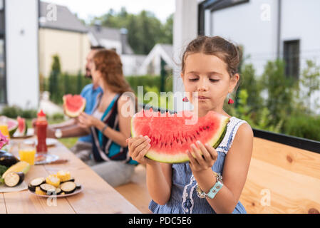 Agréable cute girl looking at la pastèque Banque D'Images