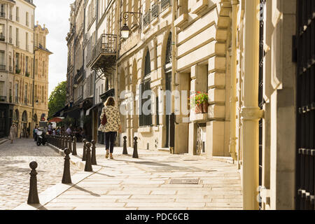 Scène de rue de Paris - une femme marchant le long de la Place Dauphine sur l'Ile de la Cité à Paris en fin d'après-midi, la France, l'Europe. Banque D'Images