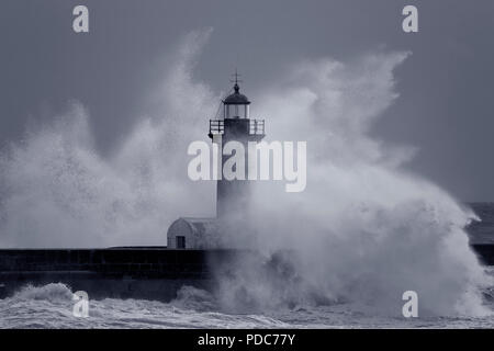 Big stormy sea splash vague sur un phare de la jetée du fleuve Douro, bouche, Porto, Portugal. Converti en noir et blanc. Tons bleu. Banque D'Images