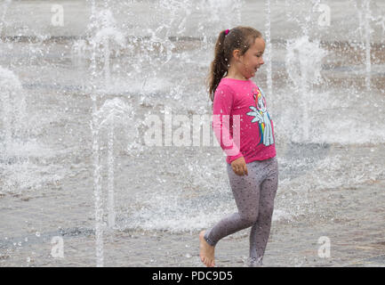 Stockton on Tees, Angleterre du Nord-Est. United Kingdom. 8 Août, 2018. Météo France : undetered par le ciel couvert et un temps plus frais, les enfants jouent dans la rue Fontaine dans Stockton on Tees, Angleterre du Nord-Est. De fortes pluies, qui seront accueillis par les agriculteurs et jardiniers, est prévue pour de nombreuses régions du Royaume-Uni à la fin de semaine Crédit : ALAN DAWSON/Alamy Live News Banque D'Images