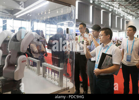 Shanghai, Chine. 8e août 2018. Visiteurs afficher les opérations de robots au cours de la réunion de jumelage pour les exposants et les acheteurs de matériel intelligent haut de gamme d'une surface d'exposition pour l'Expo 2018 China International Importer (CIEE) à Shanghai, la Chine orientale, le 8 août 2018. Shanghai est prévu d'accueillir la première CIEE à partir de 5 novembre à 10. Credit : Fang Zhe/Xinhua/Alamy Live News Banque D'Images