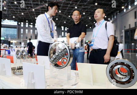 Shanghai, Chine. 8e août 2018. Un membre du personnel (L) introduit des produits portant les visiteurs pour la réunion de jumelage pour les exposants et les acheteurs de matériel intelligent haut de gamme d'une surface d'exposition pour l'Expo 2018 China International Importer (CIEE) à Shanghai, la Chine orientale, le 8 août 2018. Shanghai est prévu d'accueillir la première CIEE à partir de 5 novembre à 10. Credit : Fang Zhe/Xinhua/Alamy Live News Banque D'Images