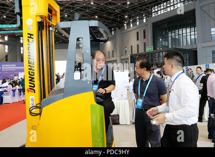 Shanghai, Chine. 8e août 2018. Un membre du personnel (L) présente une exposition pour les visiteurs au cours de la réunion de jumelage pour les exposants et les acheteurs de matériel intelligent haut de gamme d'une surface d'exposition pour l'Expo 2018 China International Importer (CIEE) à Shanghai, la Chine orientale, le 8 août 2018. Shanghai est prévu d'accueillir la première CIEE à partir de 5 novembre à 10. Credit : Fang Zhe/Xinhua/Alamy Live News Banque D'Images